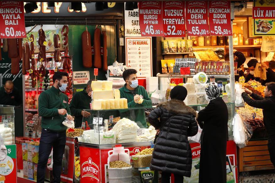 a group of people standing in front of a store: Women shop at a local market in Istanbul