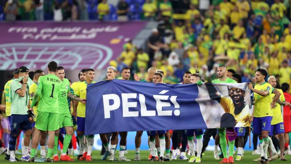 Brazilian players hold a banner showing support for legendary footballer Pele